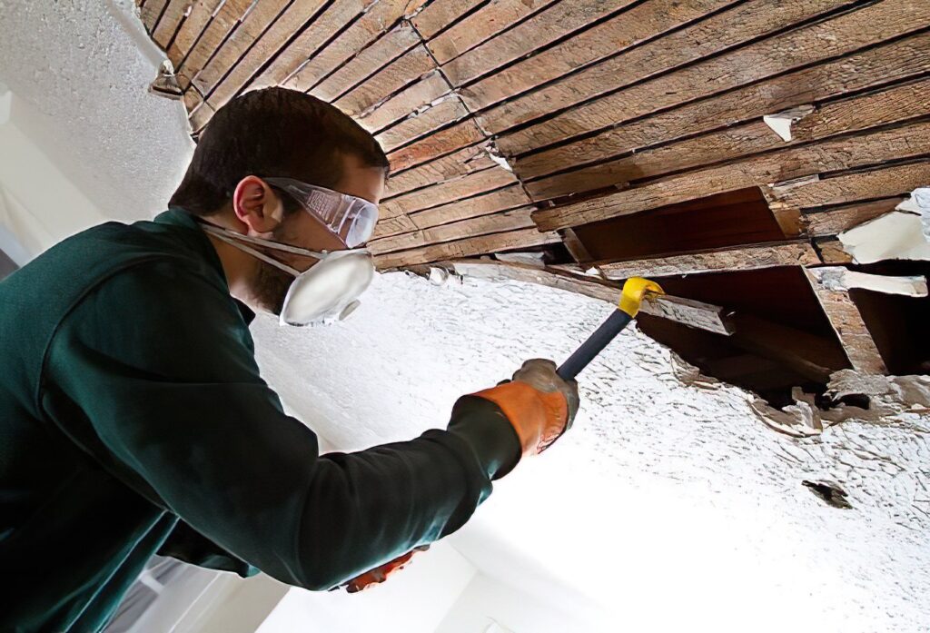 Technician cleaning soot from a fire-damaged wall