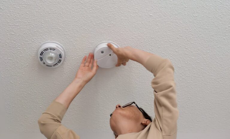 Homeowner installing smoke alarms to prevent future fire damage