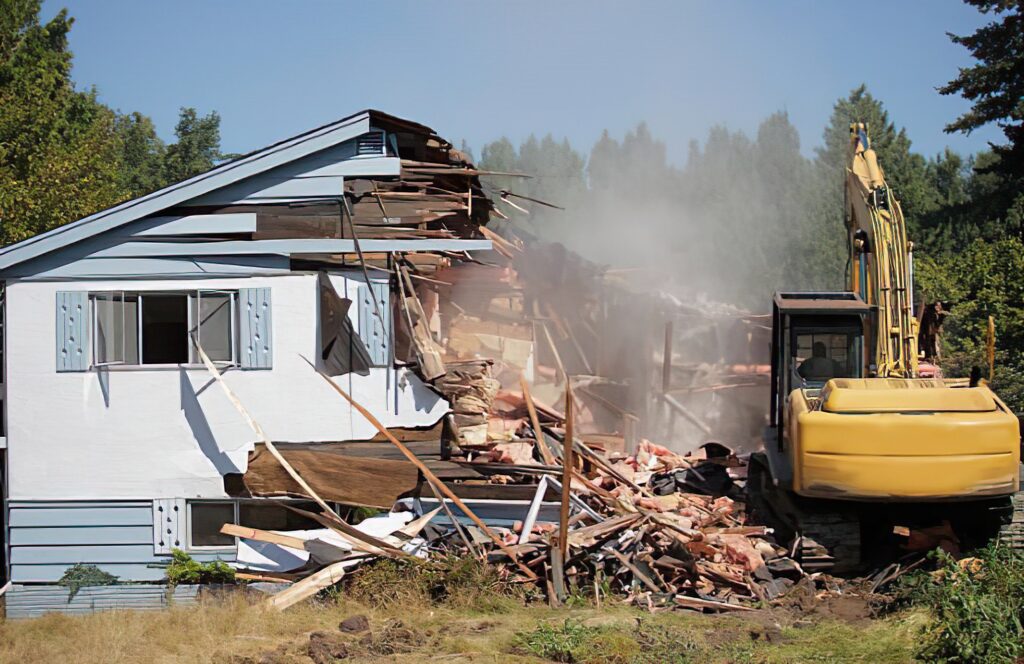 Demolition crew tearing down a building with heavy machinery