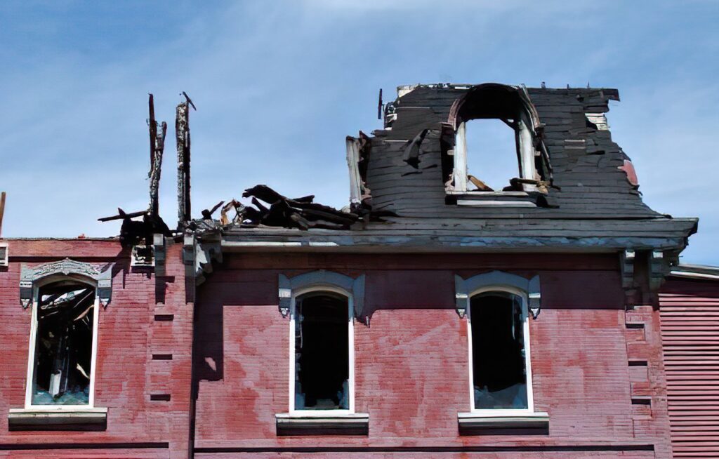 Residential home with severe fire damage and broken windows