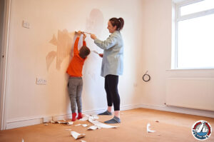 Concerned parent inspecting peeling paint on a wall in an older home.